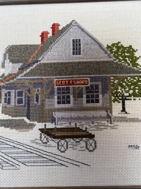 Framed Cross-Stitch Artwork Featuring a Charming Train Station Scene