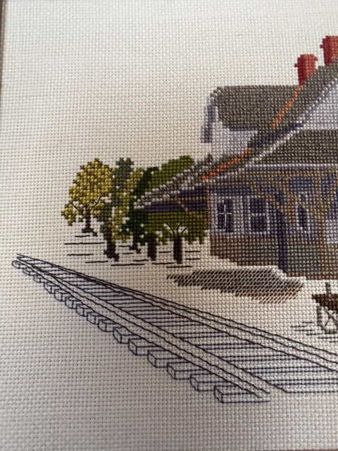 Framed Cross-Stitch Artwork Featuring a Charming Train Station Scene