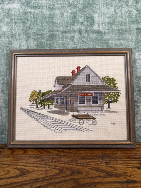 Framed Cross-Stitch Artwork Featuring a Charming Train Station Scene
